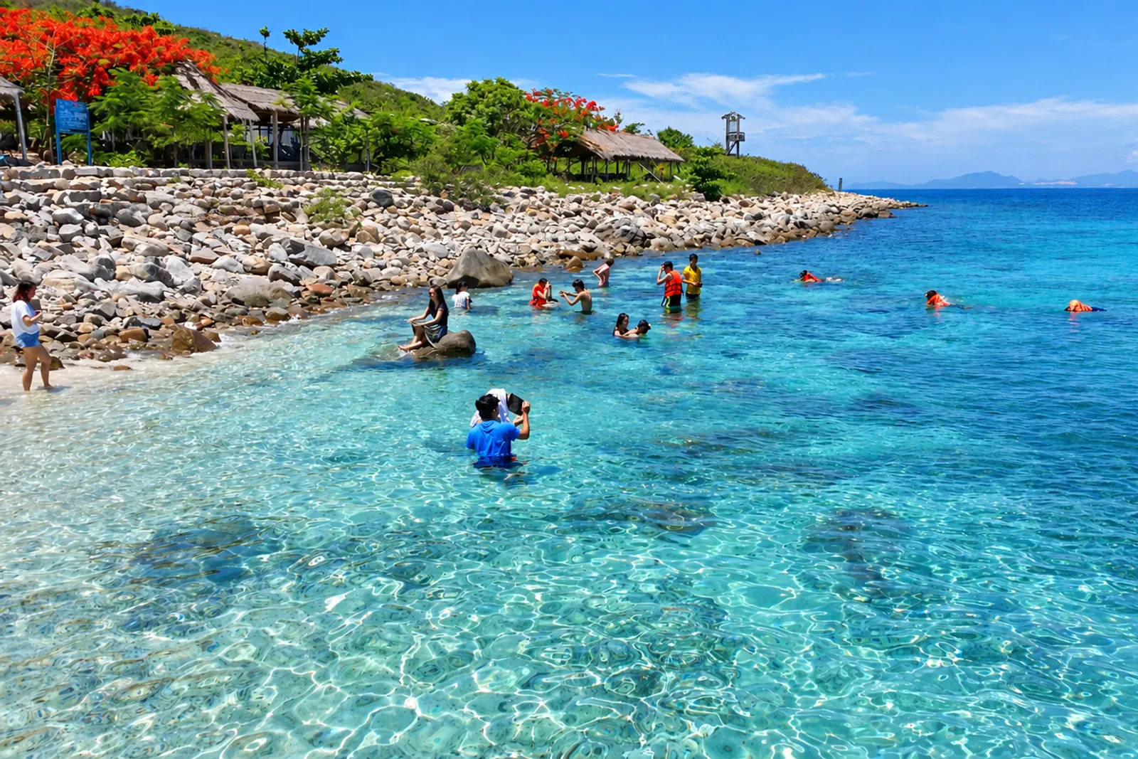 Du khách mặc áo phao, đeo kính lặn và tham gia snorkeling ngắm san hô ở Hòn Mun